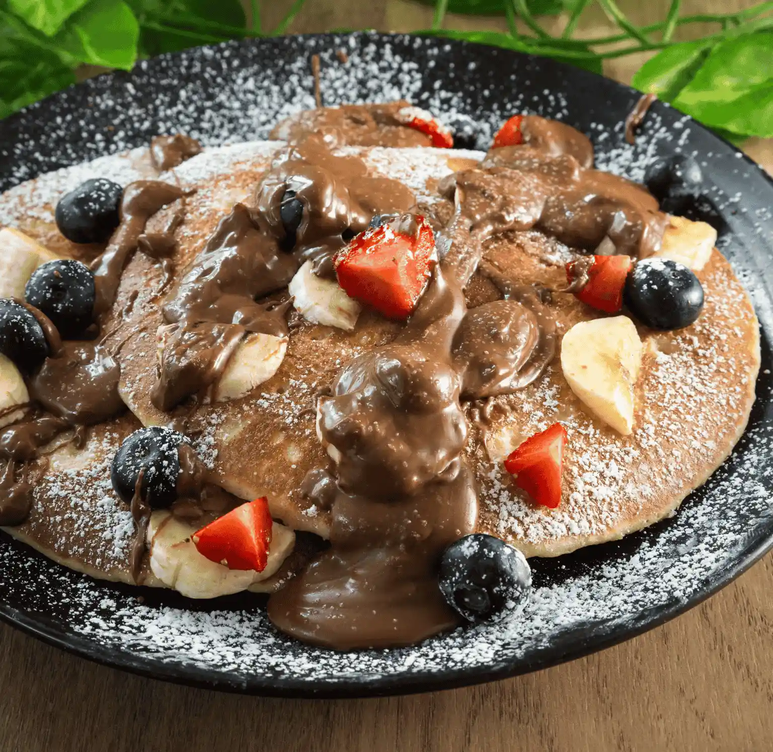 Stacked pancakes with chocolate sauce and fresh fruit at Rendezvous Cafe